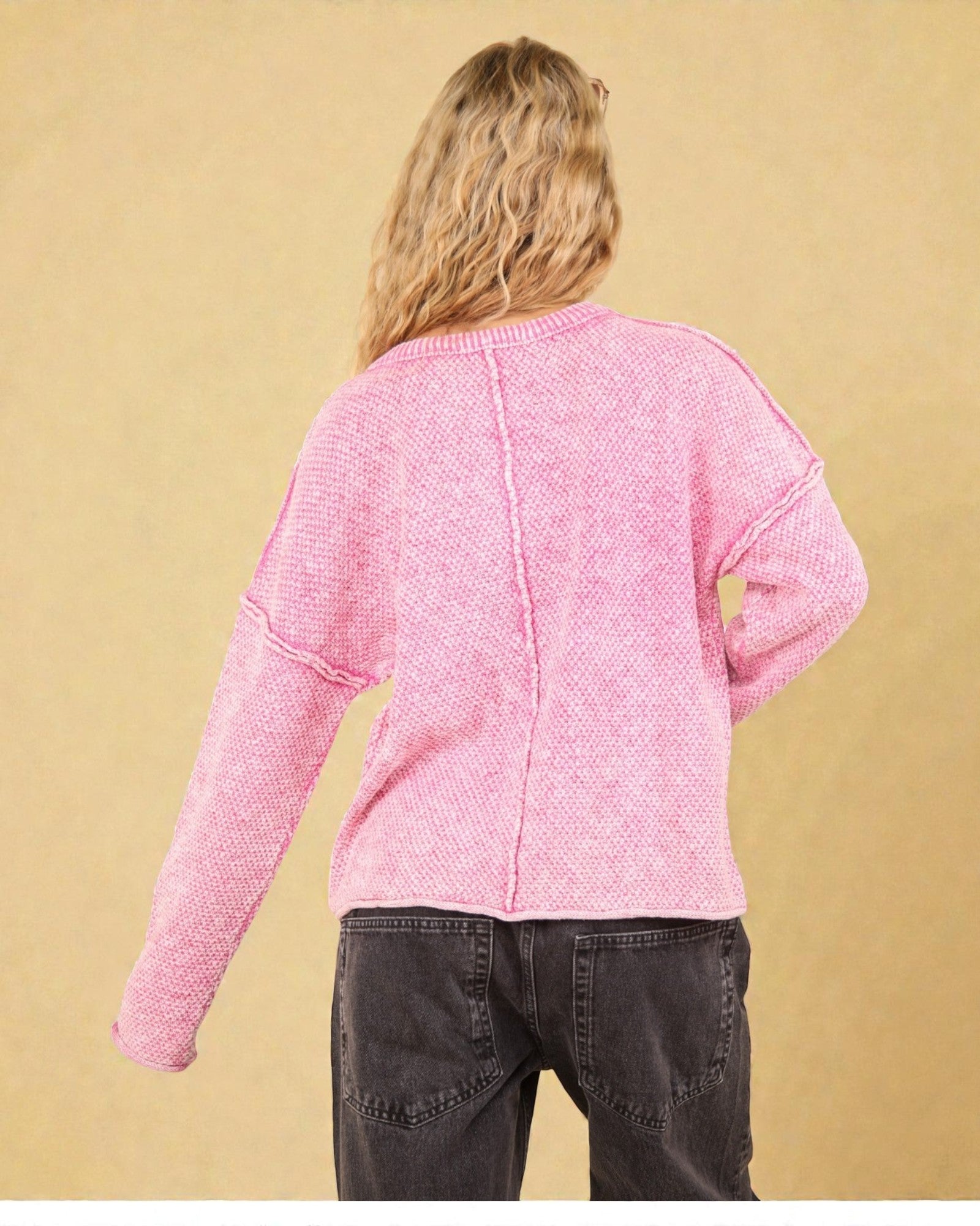 Pull rose délavé à coutures apparentes