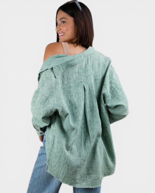 Woman wearing a green oversized jacket and blue jeans on a white background