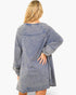 A woman shown from the back wearing a washed, acid-washed blue long-sleeve tunic sweatshirt against a plain white background.