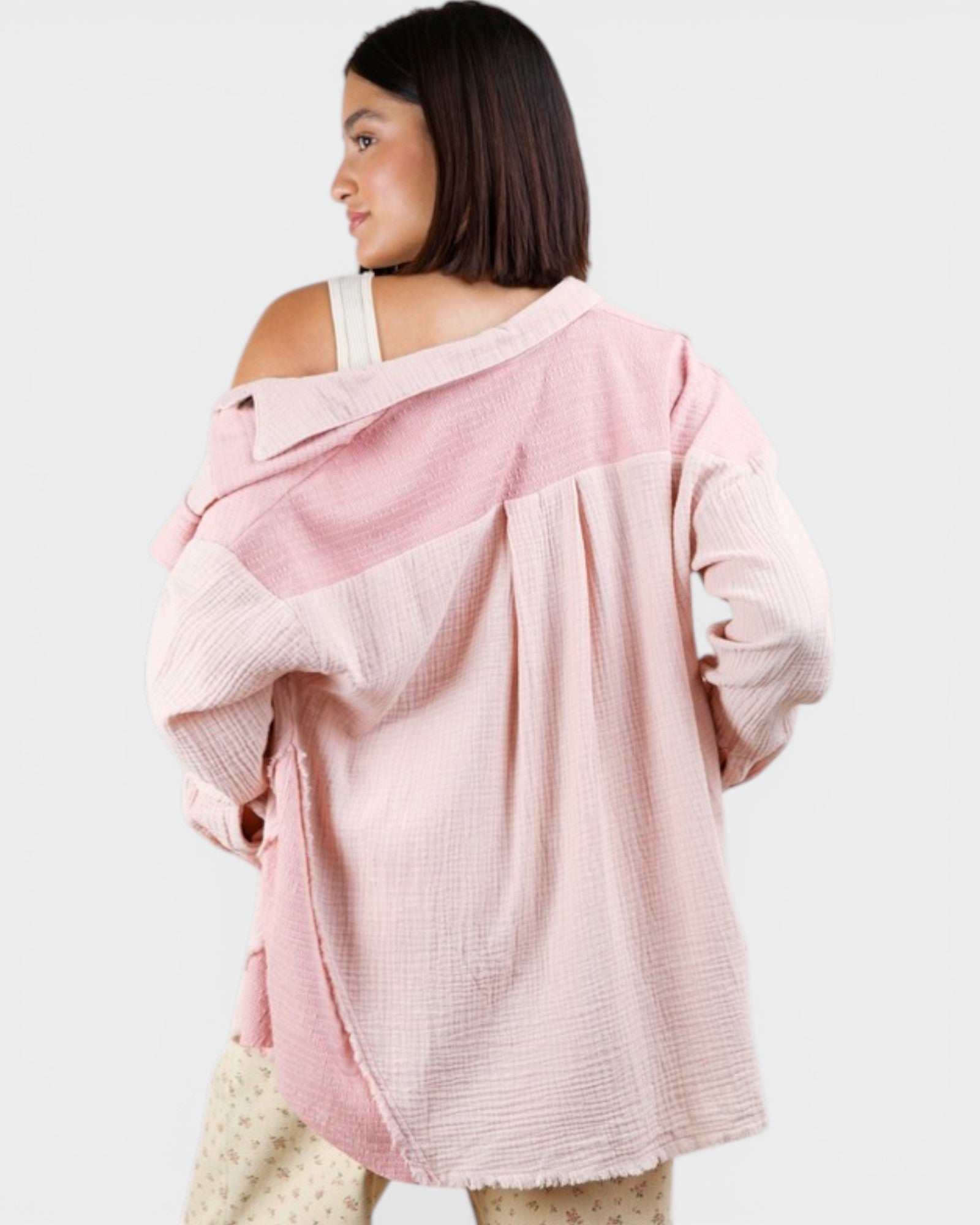 Woman wearing a pink oversized sweater on a white background
