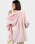Woman wearing a pink oversized sweater on a white background