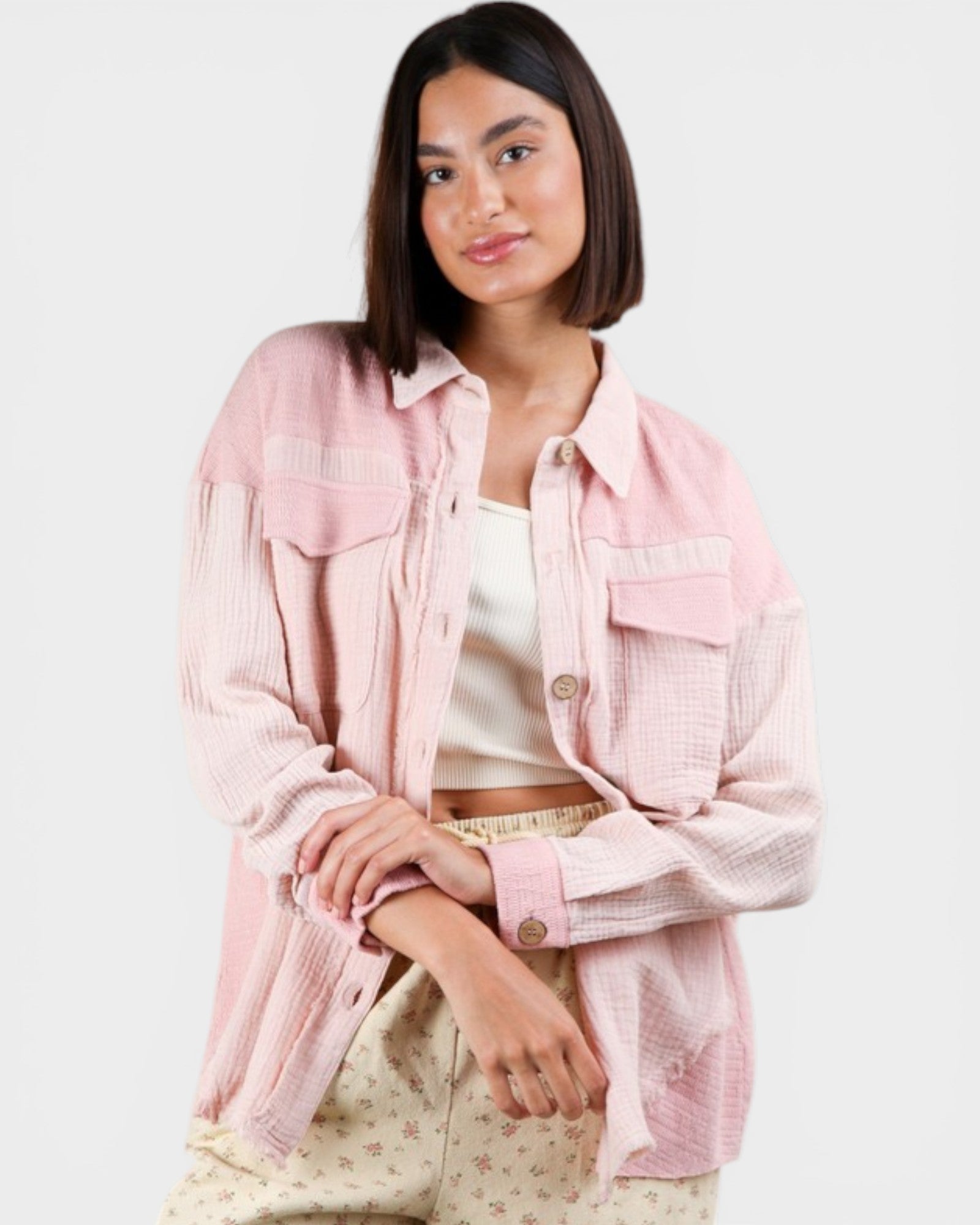 Woman wearing a light pink denim jacket on a white background