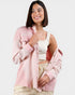 Woman wearing a pink jacket over a white top on a white background