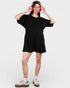 Person wearing a black oversized t-shirt and red headphones on a white background