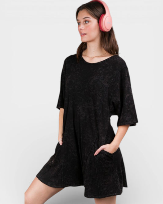 Woman wearing a black dress and pink headphones on a white background