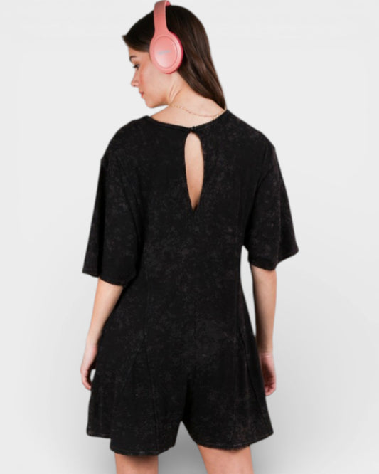 Person wearing a black dress with cut-out back design on a white background