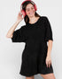 Woman wearing a black dress and pink headphones on a white background