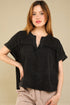 Woman wearing a black top with a beige background