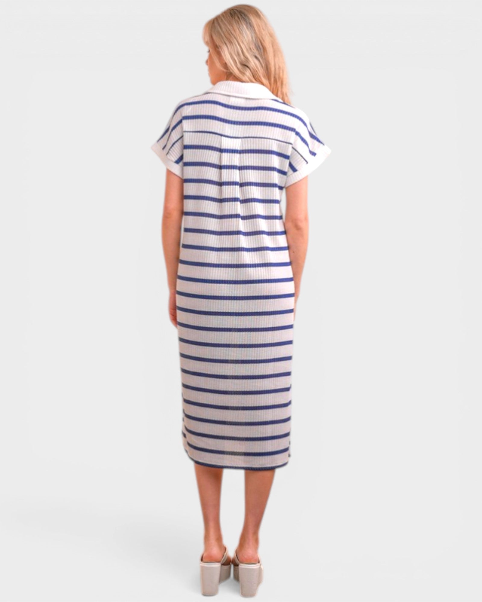 Woman wearing a striped dress on a plain background