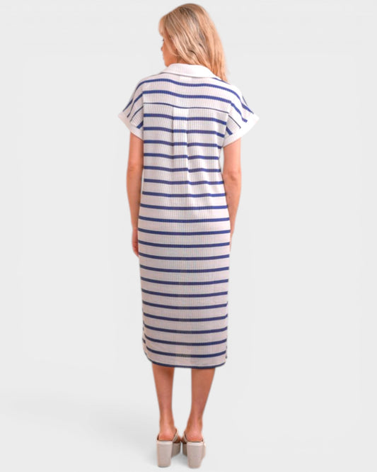 Woman wearing a striped dress on a plain background
