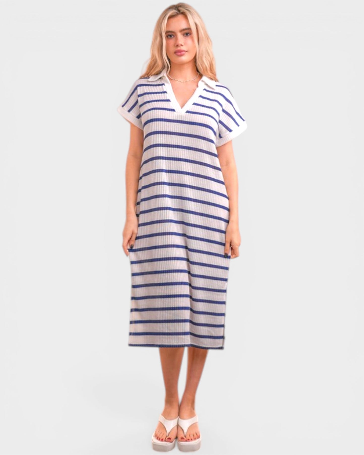 Woman wearing a blue and white striped dress on a plain background