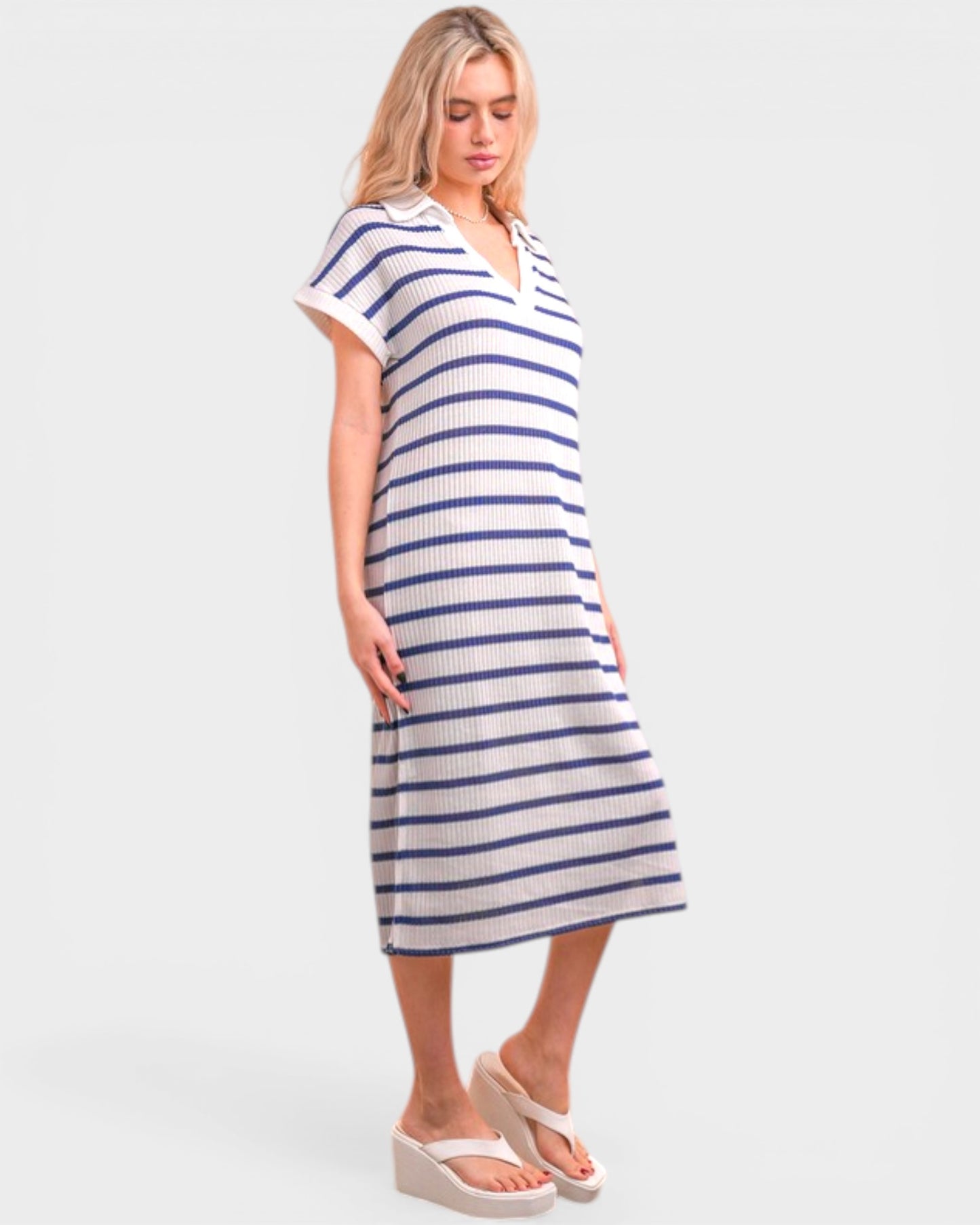 Woman wearing a blue and white striped dress on a plain background