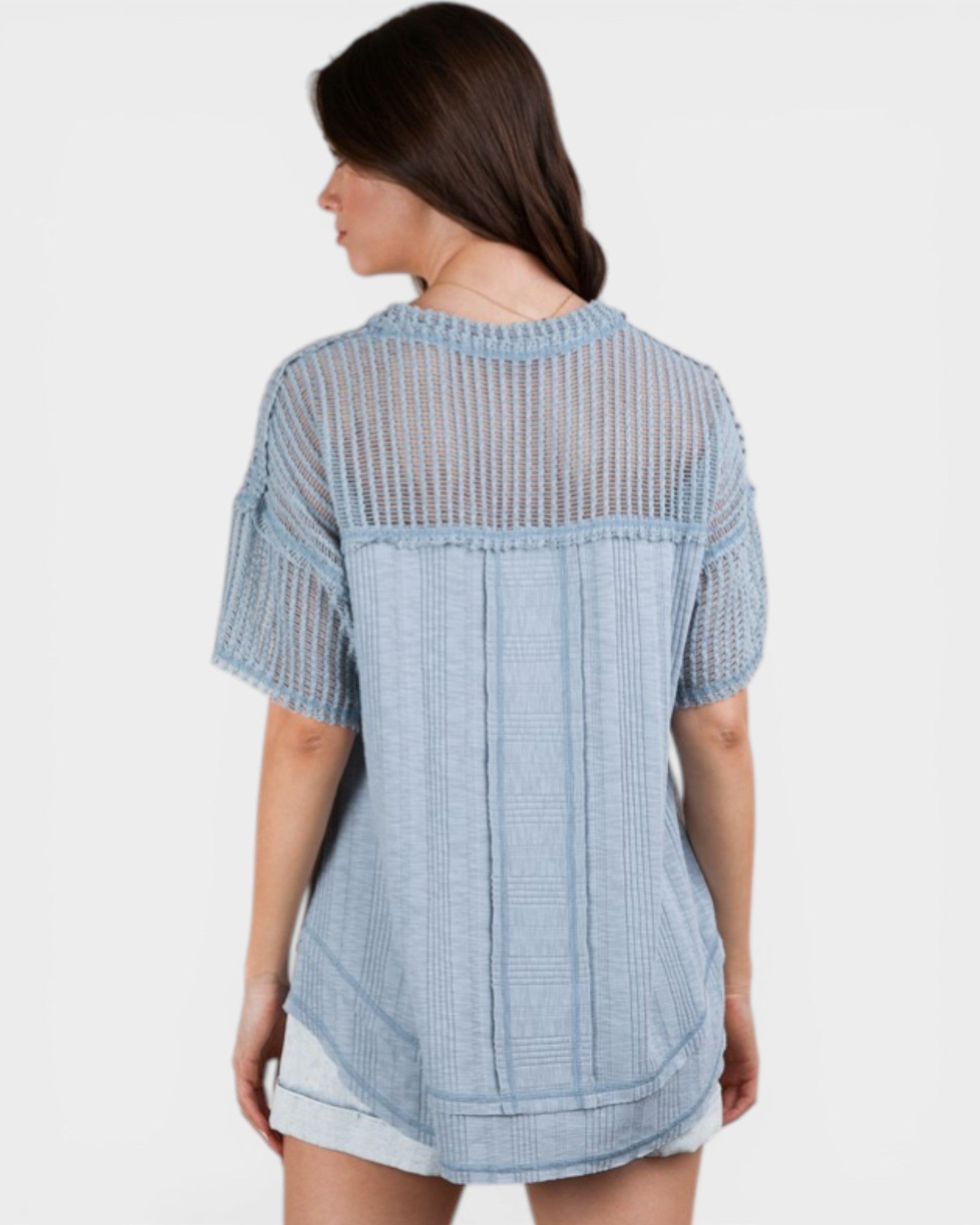 Woman wearing a light blue checkered shirt on a white background