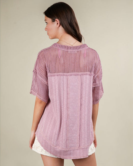 Woman wearing a pink textured top against a beige background