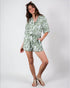 Woman wearing a green patterned romper on a white background