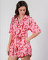 Woman wearing a pink and red patterned dress on a white background