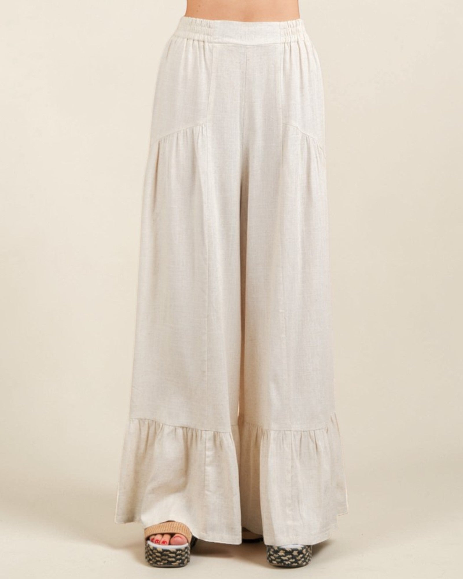 White tiered skirt worn by a person on a beige background