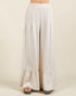 White tiered skirt worn by a person on a beige background