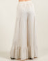 Beige wide-leg pants with ruffled bottom on a white background