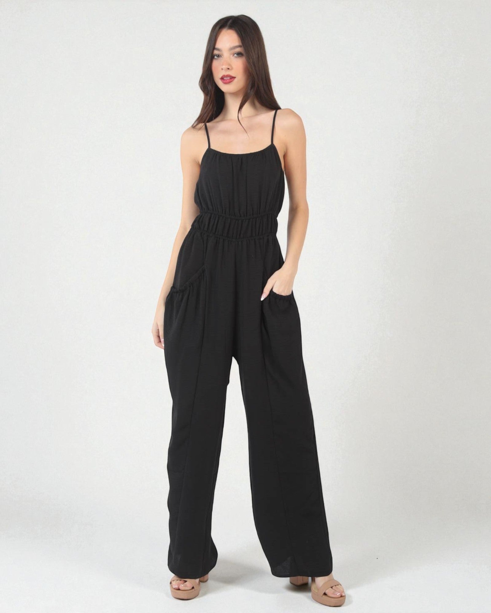 Woman wearing a black jumpsuit on a white background