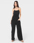 Woman wearing a black jumpsuit on a white background