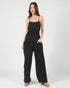 Woman wearing a black jumpsuit on a white background