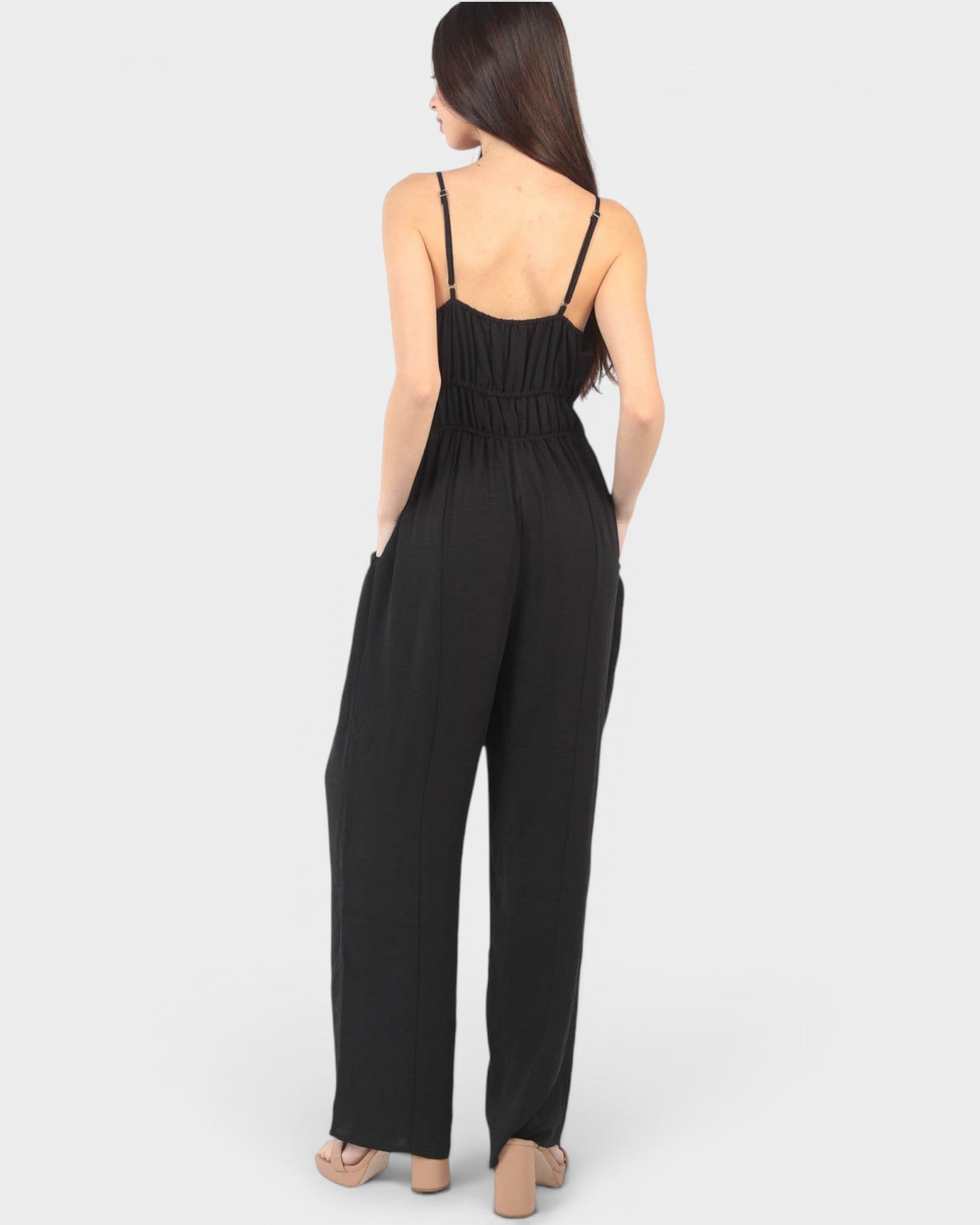 Black jumpsuit worn by a model on a white background