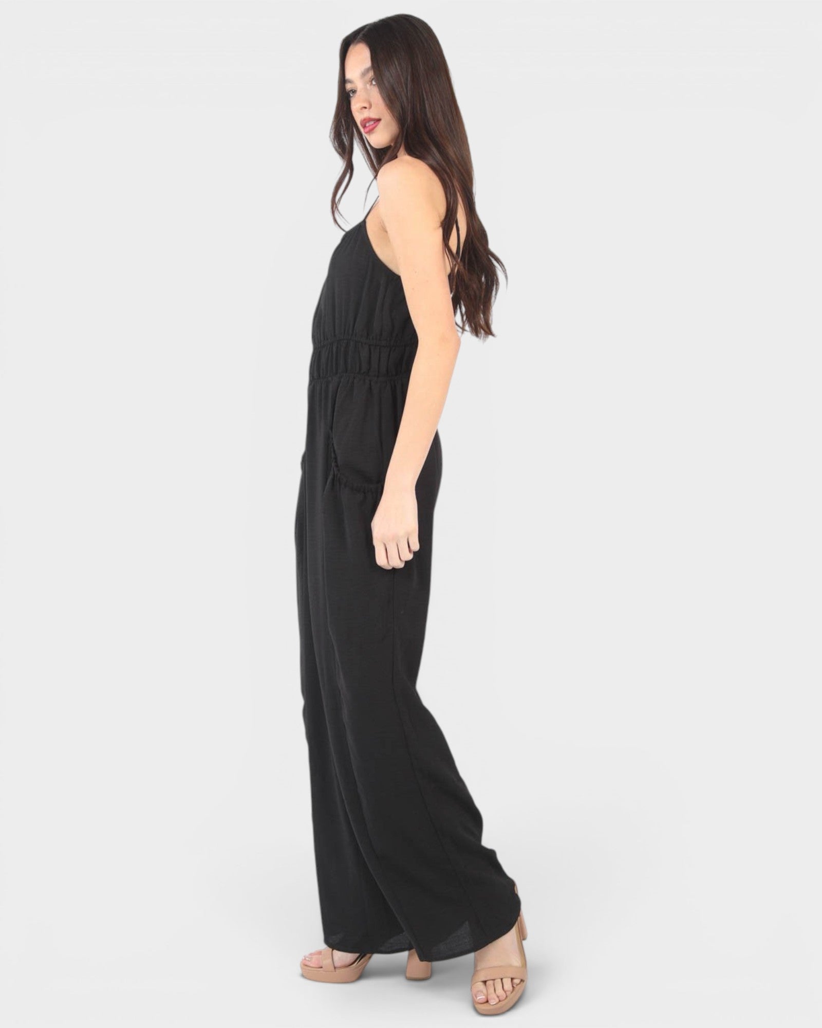 Woman wearing a black jumpsuit on a white background