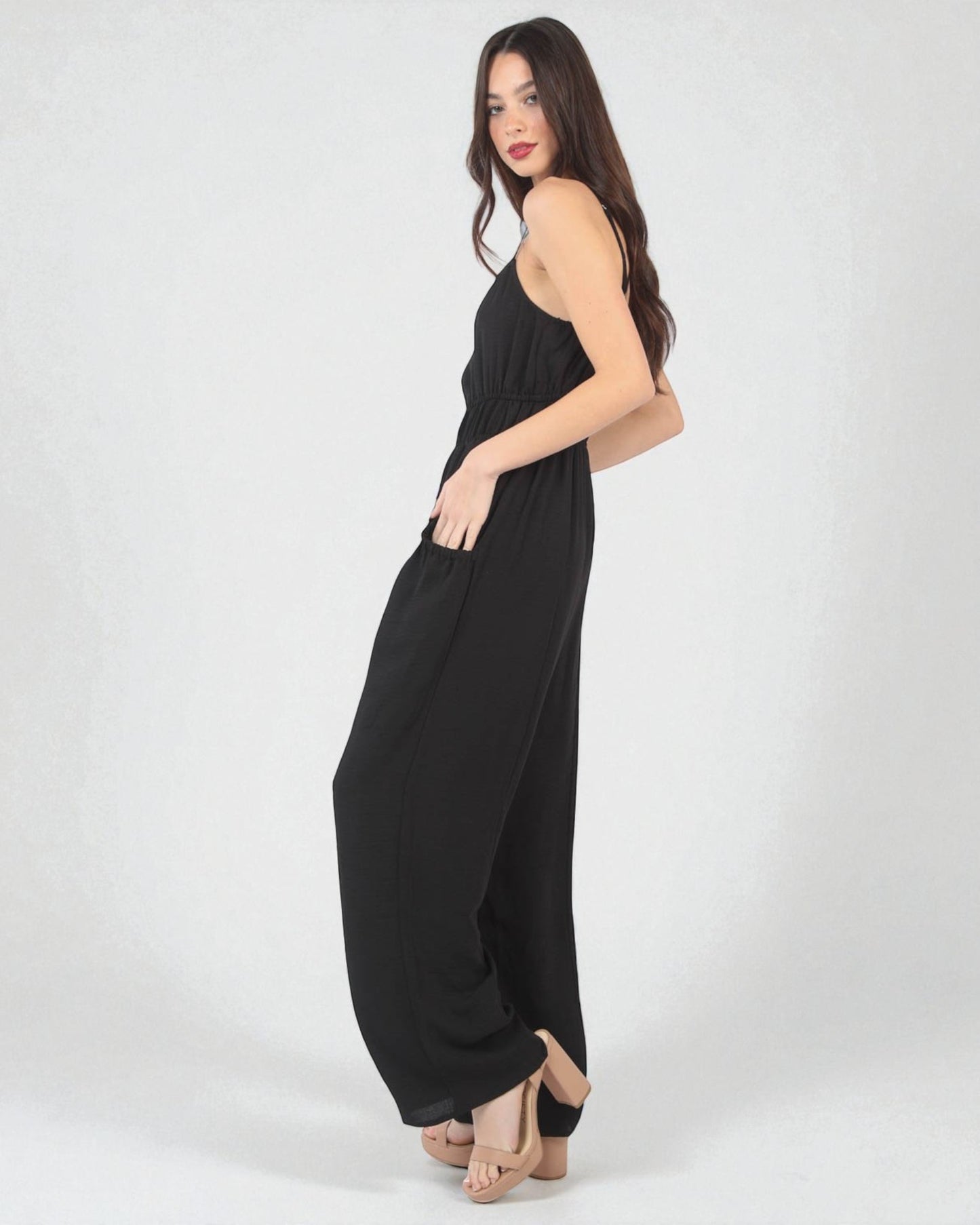 Woman wearing a black jumpsuit on a white background