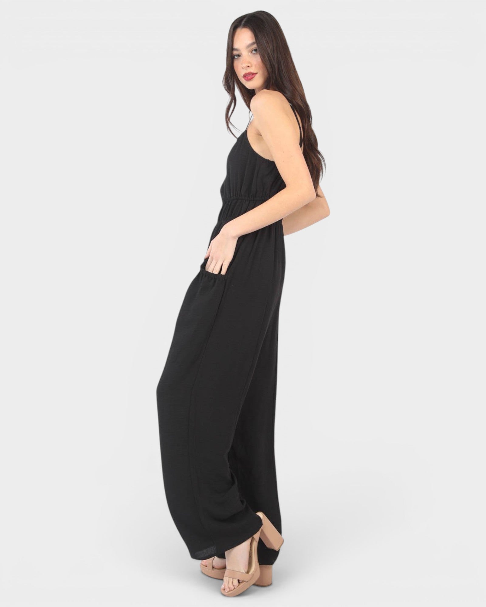 Woman wearing a black jumpsuit on a white background