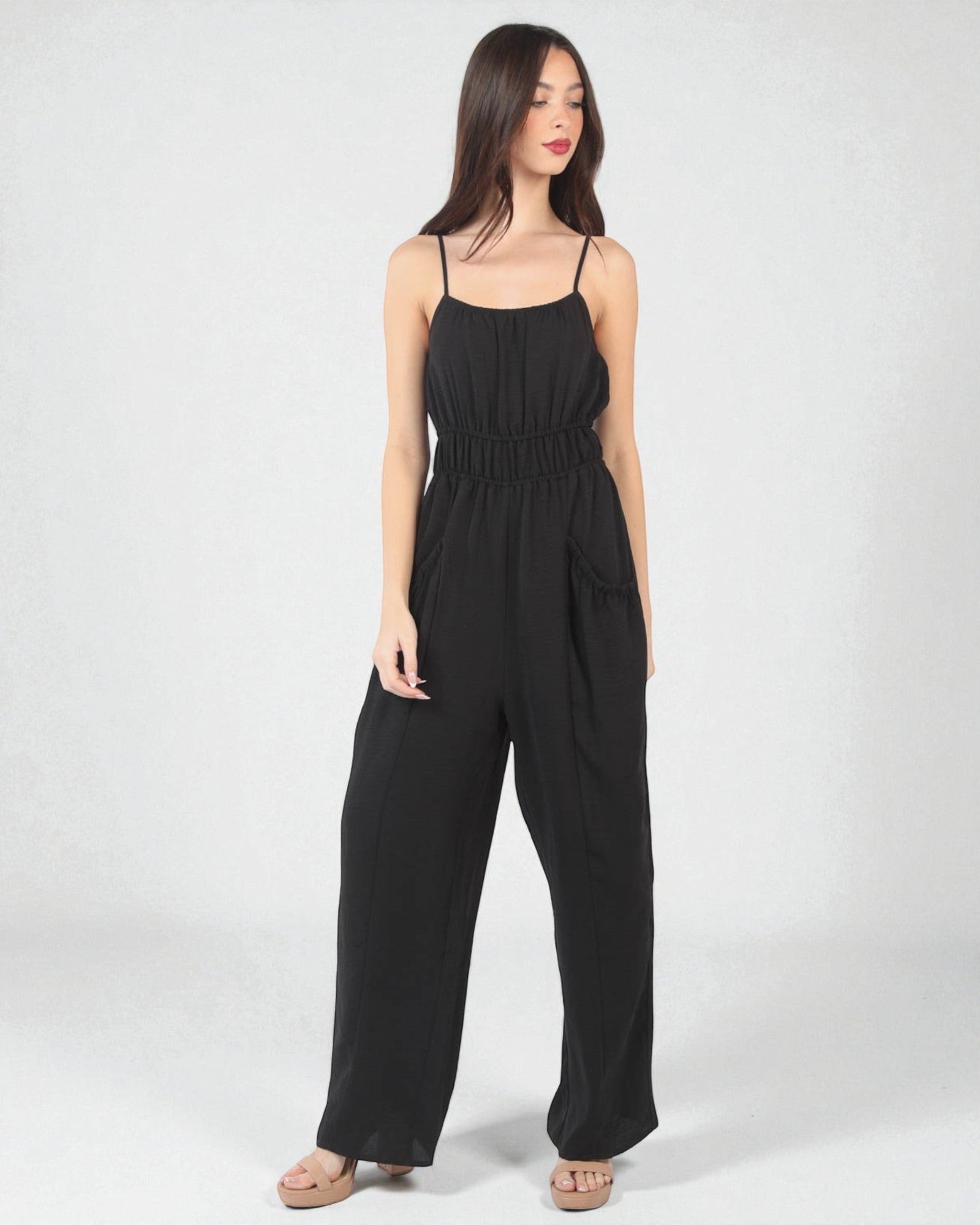 Woman wearing a black jumpsuit on a white background