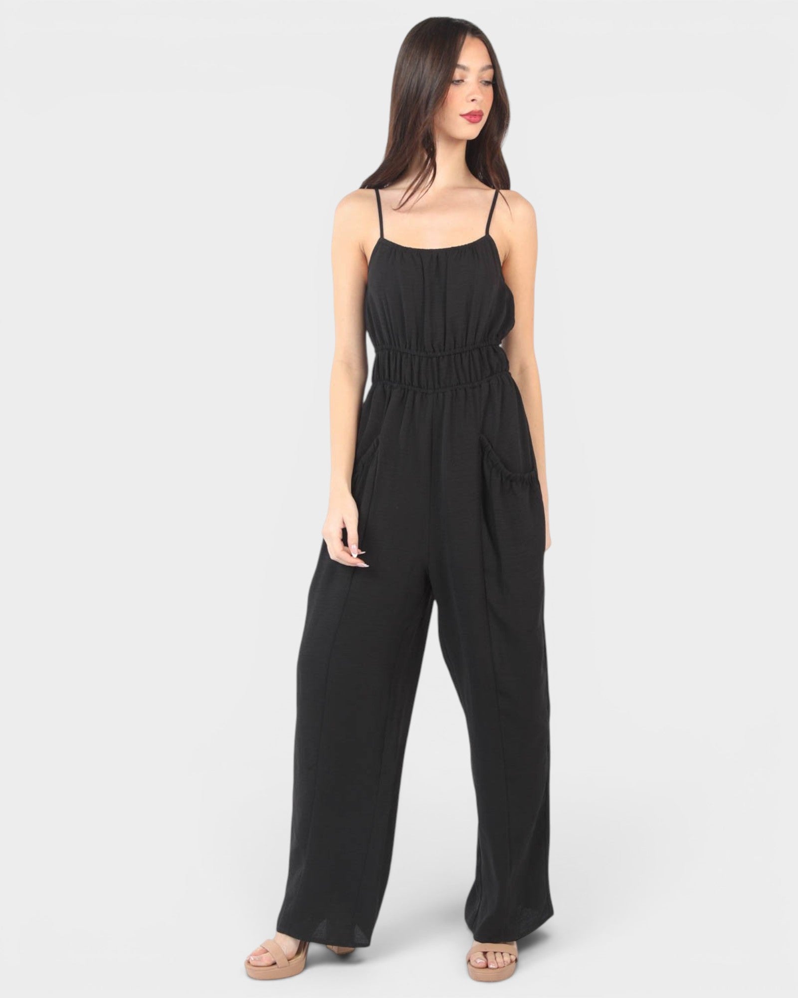 Woman wearing a black jumpsuit on a white background