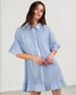 Woman wearing a light blue checkered dress against a plain background