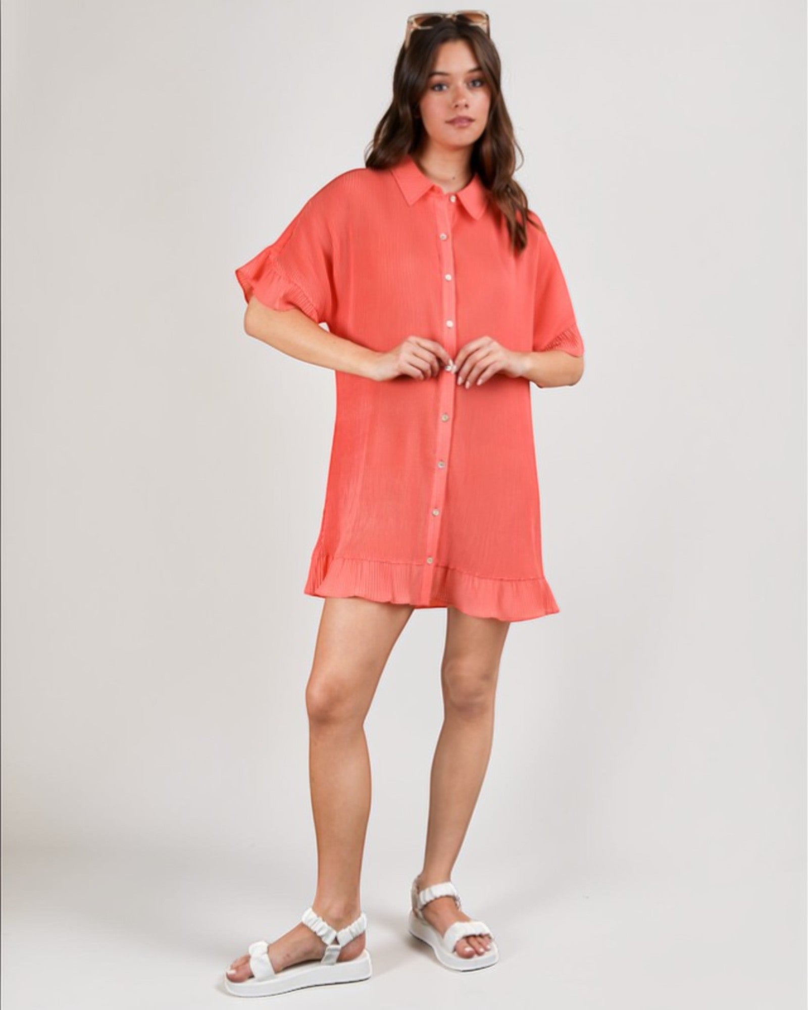 Woman wearing a coral dress on a white background