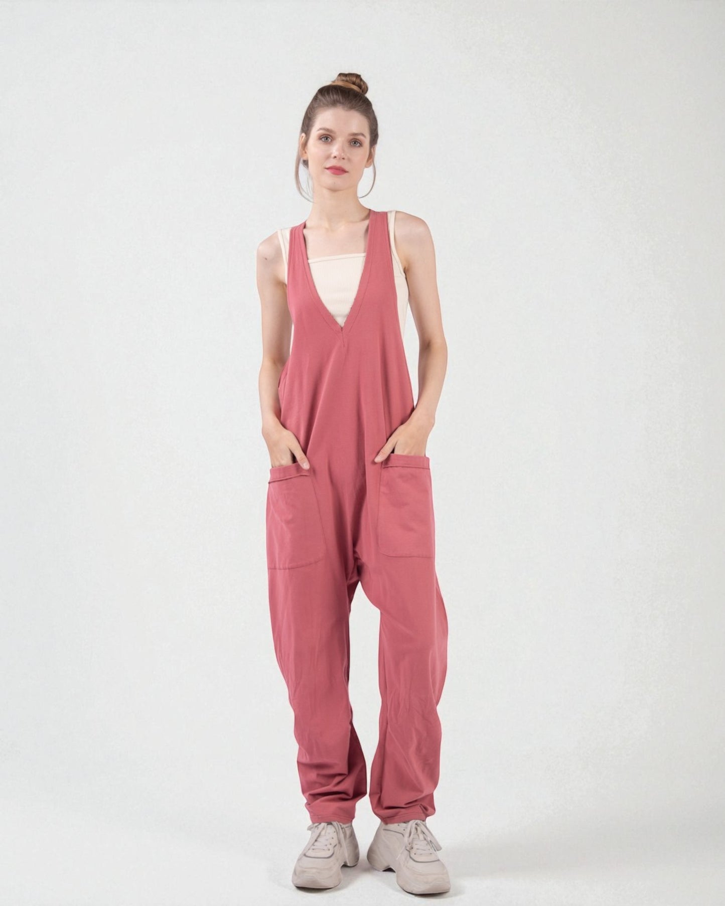 Woman wearing a pink jumpsuit on a white background