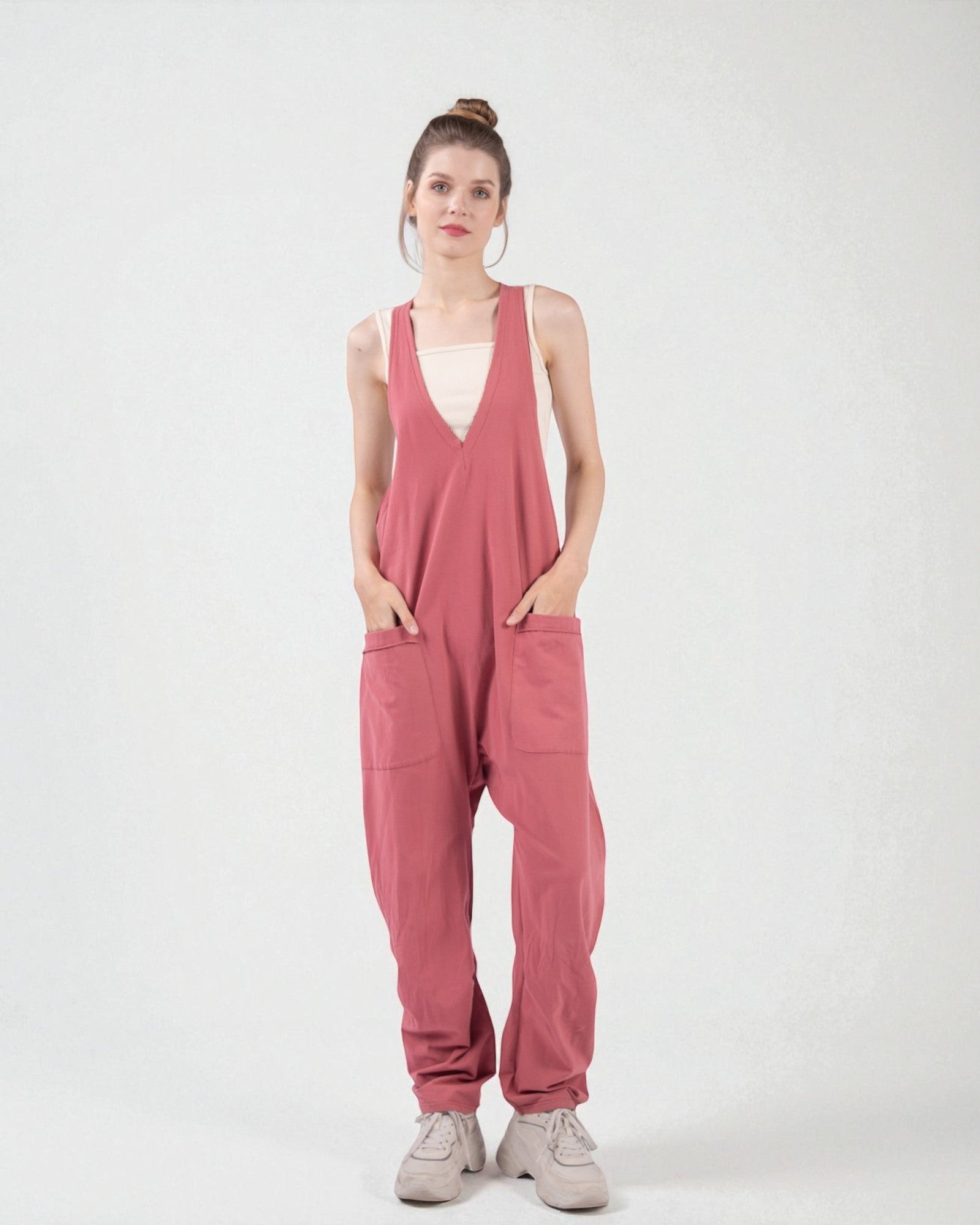 Woman wearing a pink jumpsuit on a white background