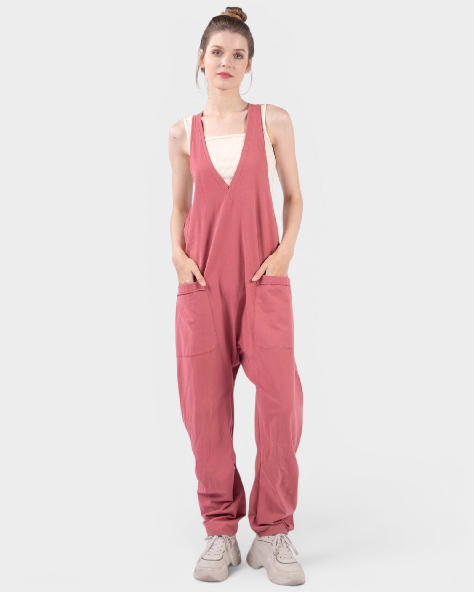 Woman wearing a pink jumpsuit on a white background