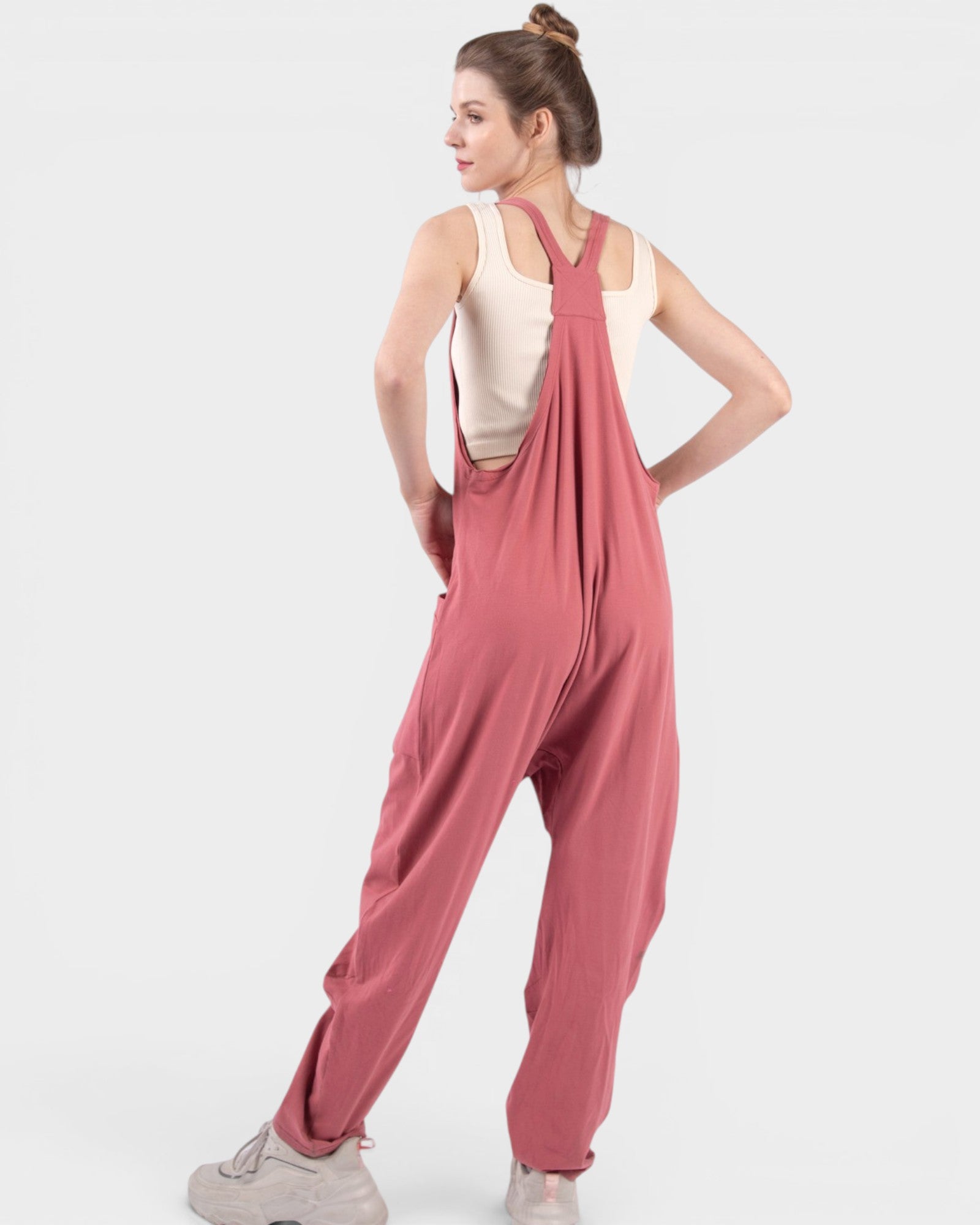 Woman wearing pink overalls on a white background
