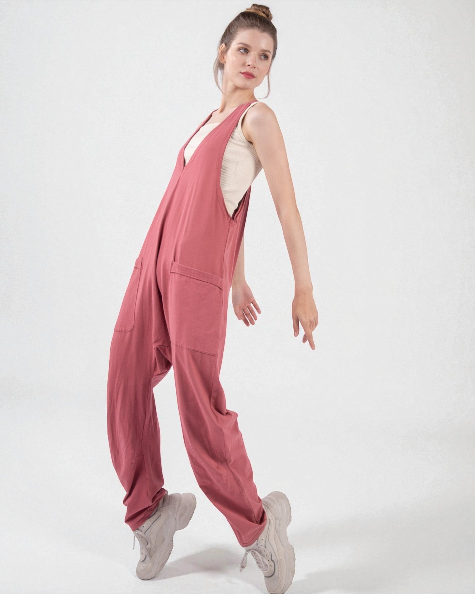 Woman wearing a pink jumpsuit on a white background