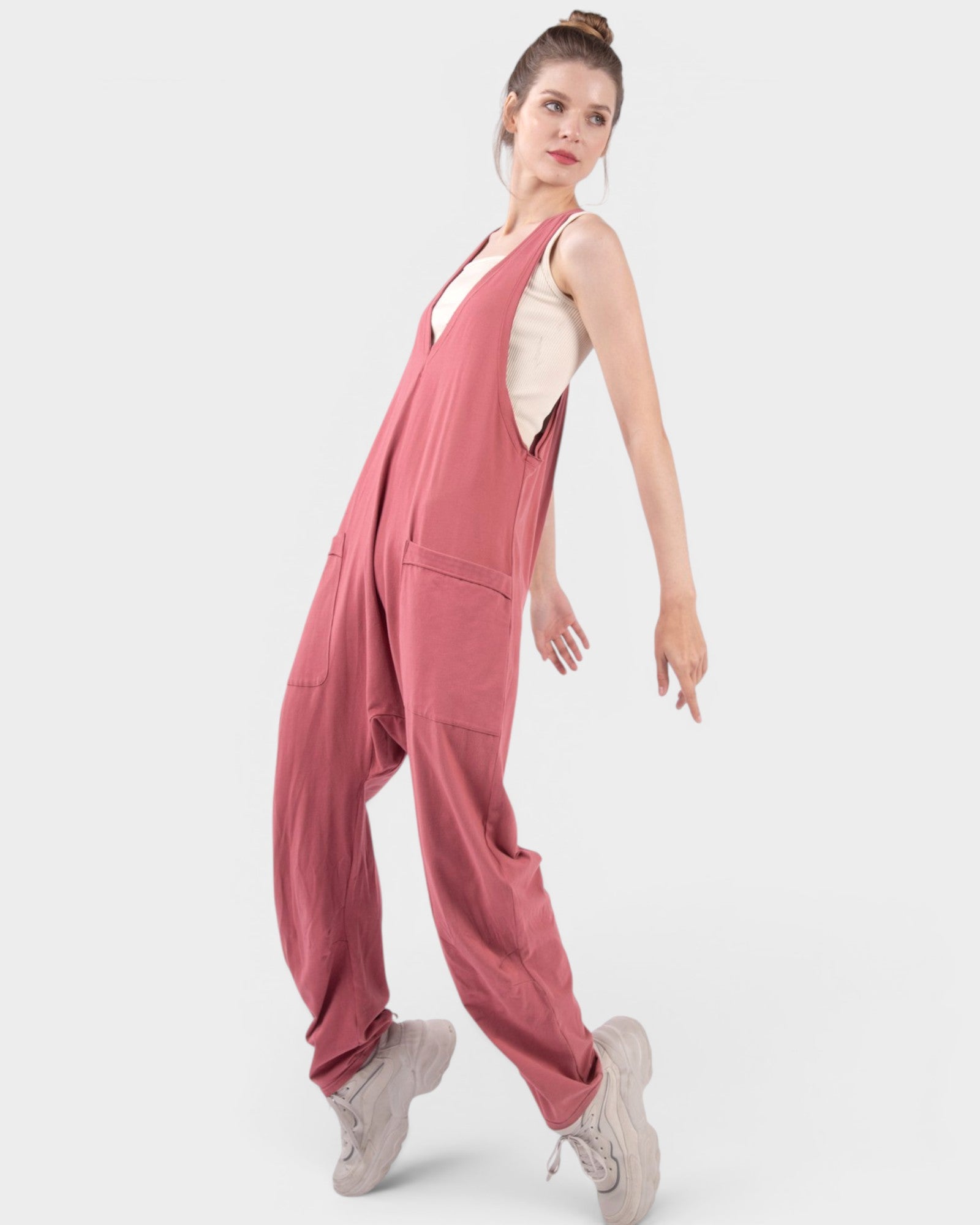 Woman wearing a pink jumpsuit on a white background