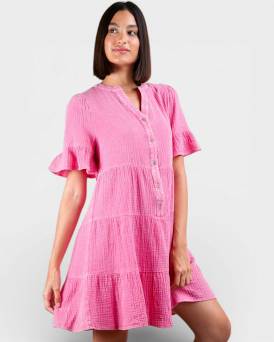 Woman wearing a pink dress against a plain background