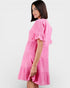 Woman wearing a pink dress against a white background