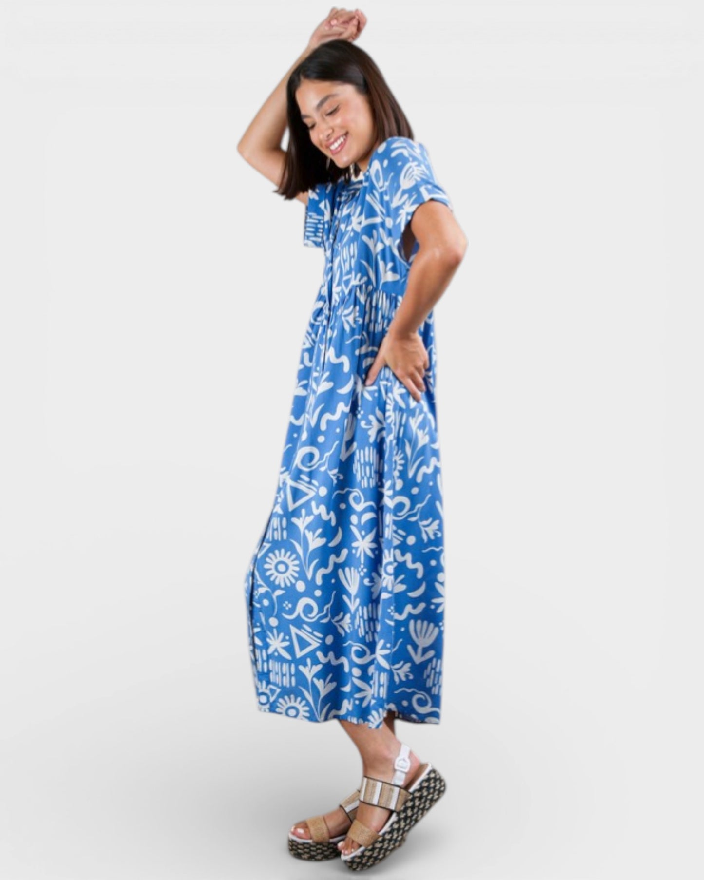 Woman wearing a blue dress with white patterns on a white background