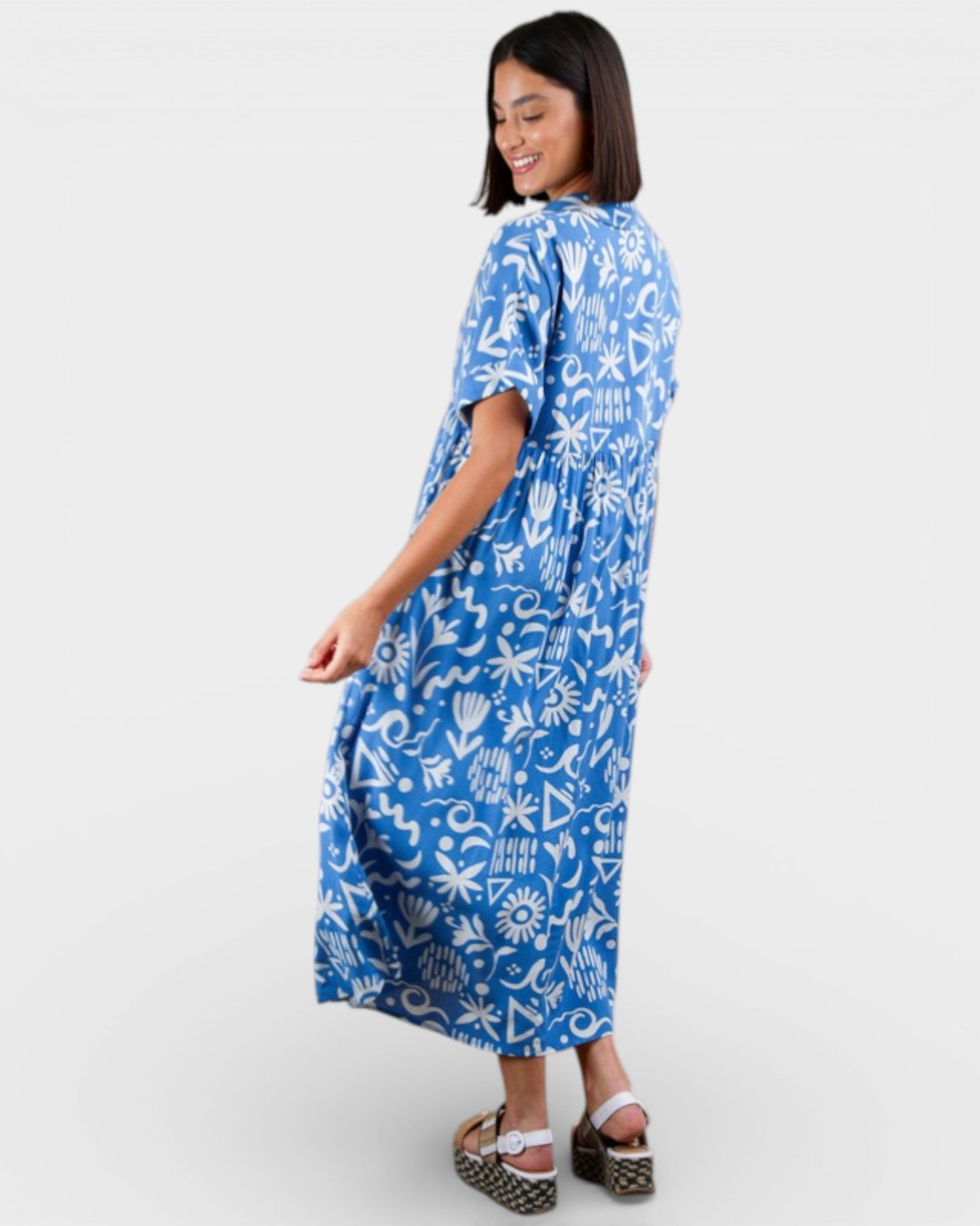 Woman wearing a blue patterned dress on a white background