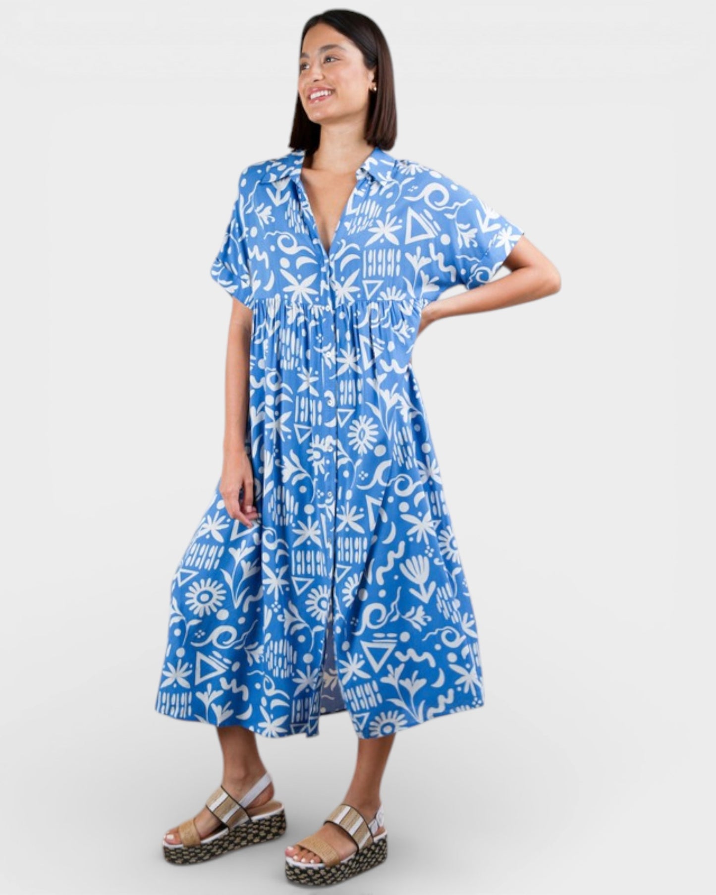 Woman wearing a blue dress with white patterns on a white background