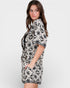 Woman wearing a black and white patterned dress on a plain background