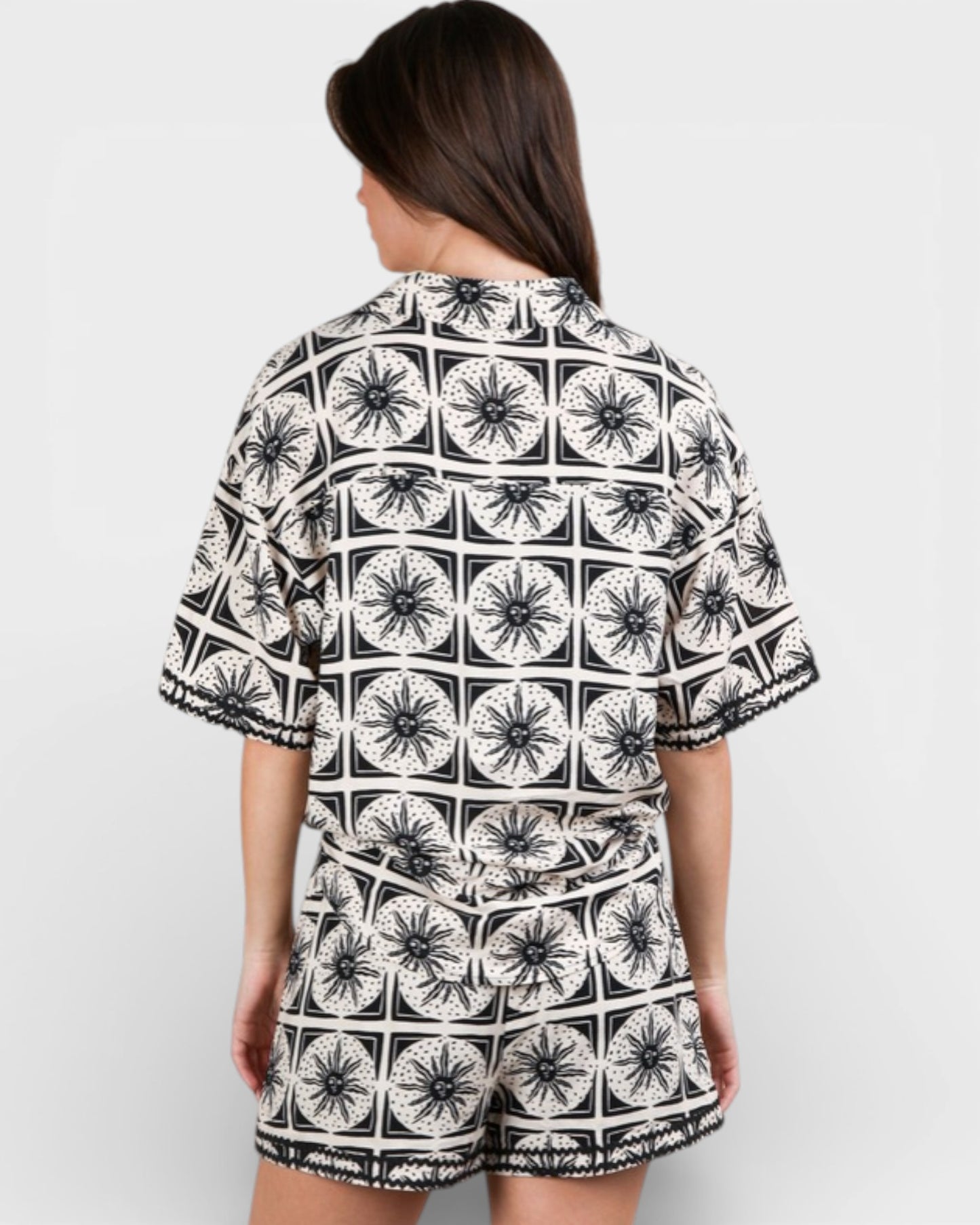 Person wearing a black and white patterned outfit on a plain background