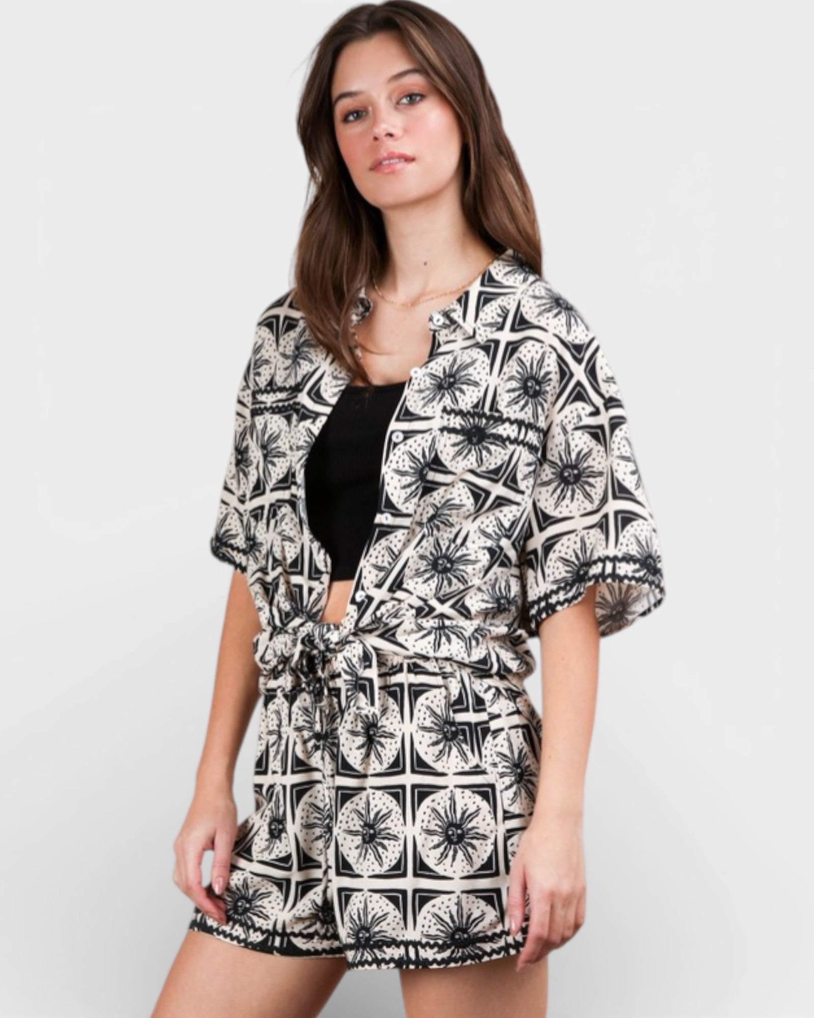 Woman wearing a black and white patterned kimono-style garment on a plain background