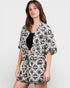 Woman wearing a black and white patterned kimono-style garment on a plain background