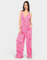 Woman wearing a pink patterned jumpsuit on a white background